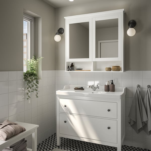 Moderner weißer HEMNES-Waschtisch mit 2 Schubladen, Waschbecken, Spiegeln. Kleines Badezimmer mit Seife, Handtüchern, Pflanzen.