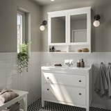 Moderner weißer HEMNES-Waschtisch mit 2 Schubladen, Waschbecken, Spiegeln. Kleines Badezimmer mit Seife, Handtüchern, Pflanzen.