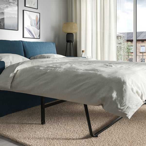 Modernes Schlafzimmer mit HYLTARP-Schlafsofa mit klarem Design, bequemen Kissen und einfachem Bettumbau.