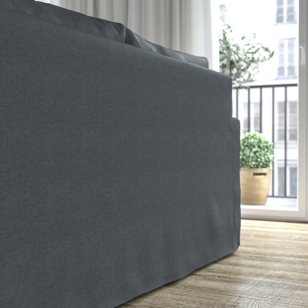 Dunkelgraues Sofa in der Nähe eines Fensters. Weiche Kissen bieten Komfort und Halt.