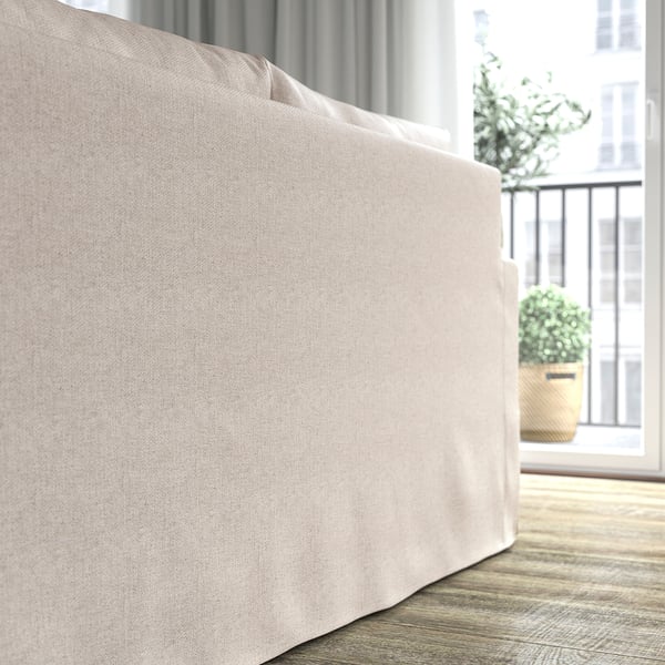 Ein beiges Sofa in der Nähe eines Fensters, mit Blick auf eine Balkonpflanze. Weiche Kissen mit hochelastischem Schaumstoff für mehr Komfort.