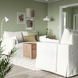 Gemütliches Wohnzimmer mit HYLTARP-Sofa, grünem Kissen, Beistelltisch und Kunst.
