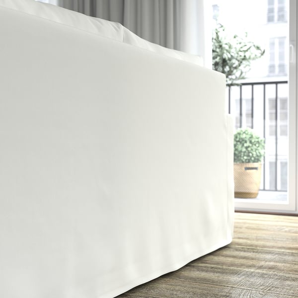 Ein weißes Sofa mit abnehmbarem, maschinenwaschbarem Bezug mit Blick auf ein Balkonfenster, das Komfort und einfache Reinigung bietet.