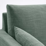 Nahaufnahme der HYLTARP-Sofas aus weichem, weichem Stoff. Bequeme, strukturierte grüne Polsterung mit klaren, modernen Linien.