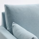 Hellblaues, modernes Sofa mit schlanken Linien und wendbaren Kissen, die einen gemütlichen und stilvollen Wohnraum schaffen.