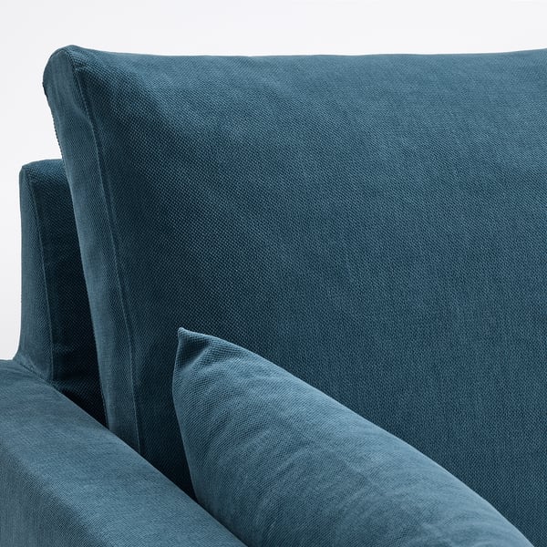Ein plüschiges blaues Sofa, elastische Schaumstoffkissen und ein gemütliches, einladendes Design, das aus hochwertigen Materialien für Komfort und Langlebigkeit gefertigt ist.