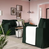 Grünes HYLTARP-Sofa in gemütlichem Wohnzimmer mit rosa Wänden, Kunstwerk und Hängelampe.