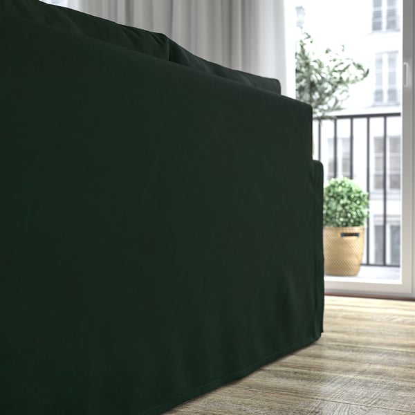 Dunkelgrünes Sofa, gemütlich und bequem, mit abnehmbarem, maschinenwaschbarem Bezug, in der Nähe von großem Fenster und Pflanzen.