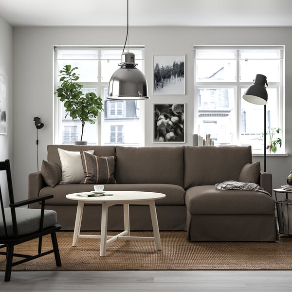 Gemütliches Wohnzimmer mit HYLTARP-Sektion, weißem Couchtisch, Stehlampe und großem Fenster.