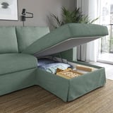 Grünes Sofa mit offenem Staufach unter der Chaiselongue, auf dem eine gefaltete Decke, Bücher und ein Brettspiel zum Vorschein kommen.