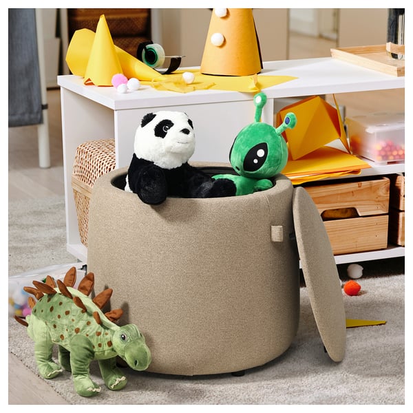 Großer grauer JÄRRESTAD Hocker zur Aufbewahrung von Spielzeug im Zimmer mit Stofftieren: Panda, Dinosaurier, Außerirdischer und Partyzubehör.
