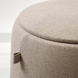 Runder Hocker mit glatter, gepolsterter Oberseite und gebogenen Seiten.