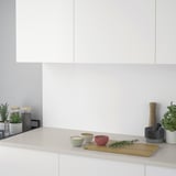 Moderne Küchenarbeitsplatte mit Gewürzen: Schüsseln, Kräuter, Pfeffermühle und Pflanze.