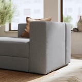 Modernes Sofa in Grau mit braunen Kissen. Weiches, modulares Design mit klaren Linien.