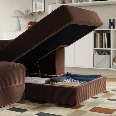 Modernes braunes Sofa mit offenem Staufach unter dem Sitz, freizügigen Kissen und Decken, eingebettet in ein gemütliches Wohnzimmer.