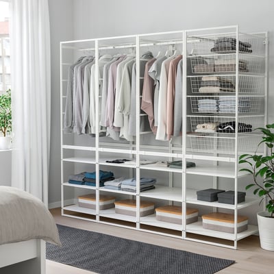 Weißer Metallschrank mit Regalen und Hängefläche, ordentlich organisiert neben einem Bett.