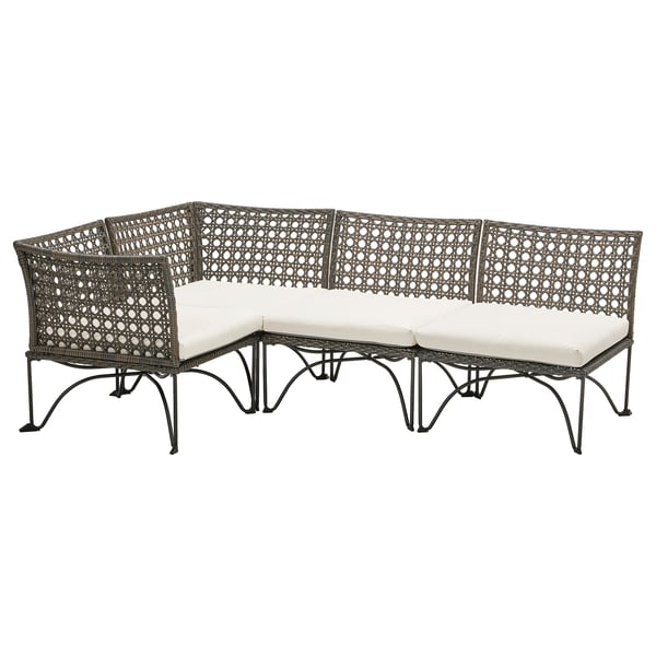 JUTHOLMEN Outdoor-Sofa aus schwarzem Korbgeflecht und weißen Kissen, angeordnet in modularer L-Form mit einem stilvollen, komplizierten Webdesign.