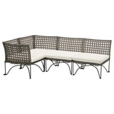 JUTHOLMEN Outdoor-Sofa aus schwarzem Korbgeflecht und weißen Kissen, angeordnet in modularer L-Form mit einem stilvollen, komplizierten Webdesign.