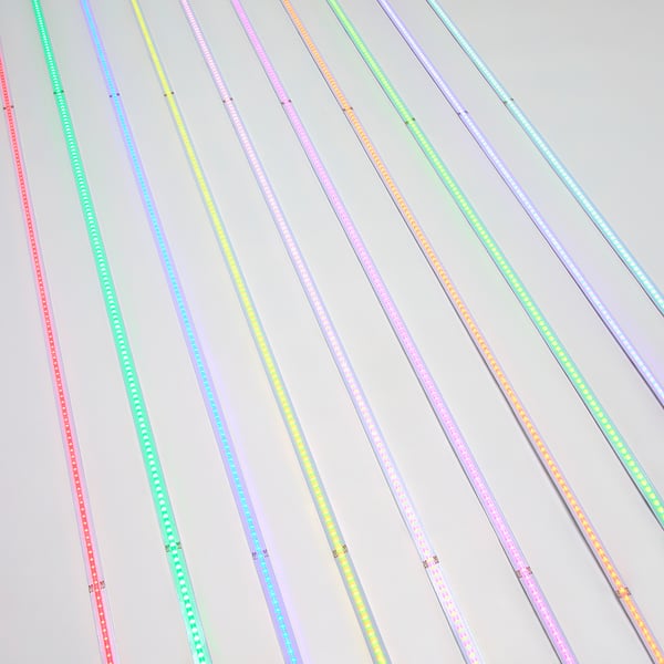 Bunte LED-Lichtleisten mit USB-Anschlüssen, die mehrere Farben und Muster anzeigen, diagonal auf einem hellen Hintergrund angeordnet.