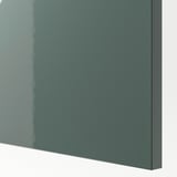 Nahaufnahme der hochglänzenden grau-grünen Abdeckplatte. Glatte, reflektierende Oberfläche, die auf eine hochwertige Verarbeitung hinweist.