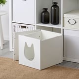 Weiße KALLAX Katzentoilette mit sicherem Katzeneingang, platziert in einem Raumteiler.