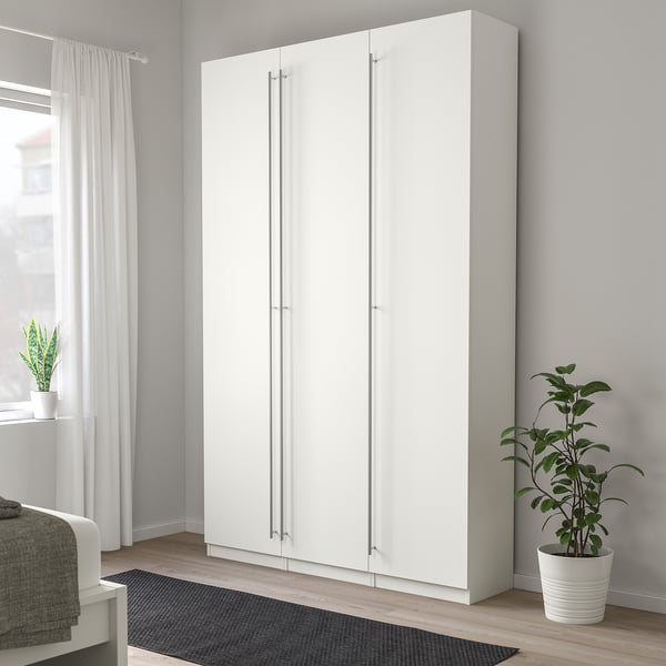 Weißer KALLRÖR Kleiderschrank im Zimmer mit grauem Teppich, Vorhängen, Pflanze.