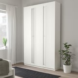 Weißer KALLRÖR Kleiderschrank im Zimmer mit grauem Teppich, Vorhängen, Pflanze.