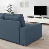 Modernes Wohnzimmer mit großem blauem KIVIK-Sofa, elegantem TV-Ständer und stilvoller Einrichtung.