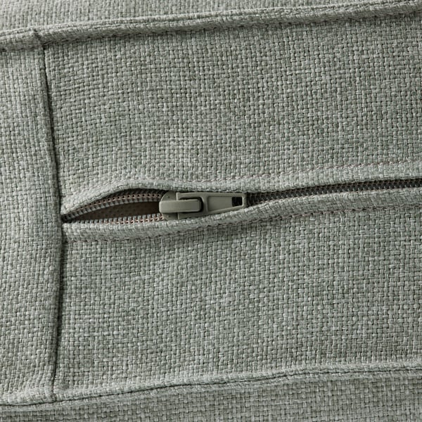 Nahaufnahme der Reißverschlusstasche der KIVIK-Sofas mit robustem Stoff und glattem Reißverschluss.