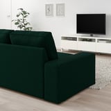 Modernes Wohnzimmer mit großem grünem KIVIK-Sofa, weißem TV-Ständer und Wandkunst.