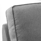 Nahaufnahme der Armlehne und Rückenlehne eines grauen Sofas mit hochwertigen Stoffen und Nähten.