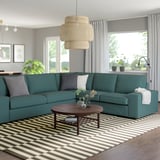 Blaugrünes L-förmiges Sofa im modernen Wohnzimmer mit Couchtisch und Streifenteppich.