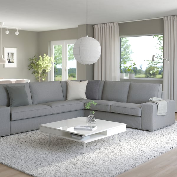 Modernes Wohnzimmer mit KIVIK-Sofa, Couchtisch, großem Fenster und Teppich.