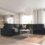 Modernes Wohnzimmer mit großem KIVIK-Sofa, Teppich, Kissen und Tageslicht.