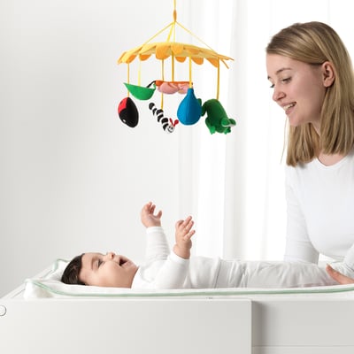 KLAPPA buntes Baby-Mobile mit rotem Marienkäfer, grüner Raupe und blauem Blatt. Leuchtend gelber Gänseblümchen-Hintergrund. Weiche Stoffmaterialien.