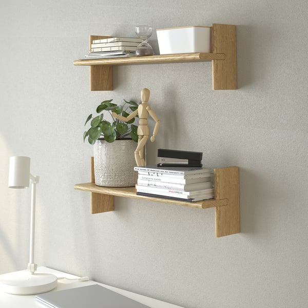 Wandmontierte Holzregale mit Büchern, Pflanzen und Dekorationsartikeln.