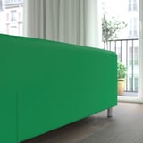 Hellgrünes Sofa in der Nähe des Fensters, das bequeme Sitzgelegenheiten mit strapazierfähigem, maschinenwaschbarem Bezug bietet.