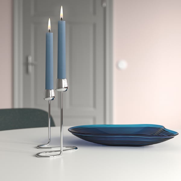 KLOKHET zwei blaue Kerzen auf silbernem Halter, klein. Auf Tisch mit Glasschale, elegantes Ambiente.