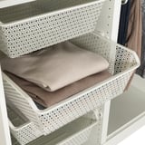 Der weiße KOMPLEMENT-Korb aus Mesh hält gefaltete Kleidung im Kleiderschrank und fördert die Luftzirkulation.