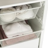 Netzkorb hält gefaltete Decken im Schrank und sorgt so für Luftzirkulation und Sichtbarkeit.