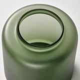 Vase aus mattgrünem Glas, kreisförmige Platte, glatte Oberfläche. Handgefertigtes, elegantes Design.