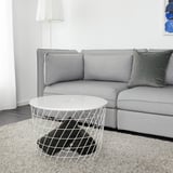 Modernes Wohnzimmer mit grauem Sofa, weißem KVISTBRO-Tisch und schwarzer Decke.