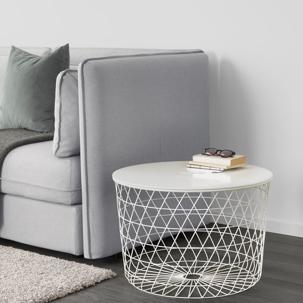 Modernes Wohnzimmer mit grauem Sofa, grünen Kissen und Beistelltisch mit Büchern und Gläsern.