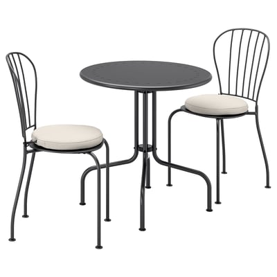 Schwarzer Outdoor-Tisch aus Metall mit zwei passenden Stühlen, cremefarbenen Kissen. Klassischer schmiedeeiserner Stil.