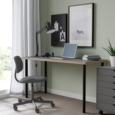 LAGKAPTEN Schreibtisch: schlankes schwarzes, modernes Design. Laptop & Bücher passen gut. Grauer Stuhl und Lampe in der Nähe. Dekorative Kunst an der Wand.