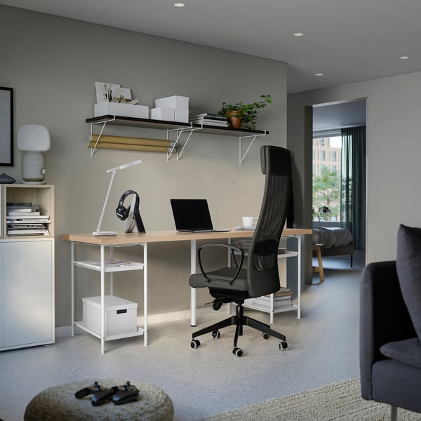Home-Office-Einrichtung mit einem großen LAGKAPTEN-Schreibtisch mit schwarzem Stuhl, minimalistischem Dekor und wandmontierten Regalen, ideal zum Arbeiten und Entspannen.