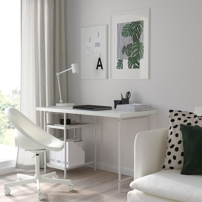 Minimalistisches Home Office mit weißem Schreibtisch, Stuhl, Vorhängen und Holzboden. Das Dekor umfasst abstrakte und pflanzliche Wandkunst.