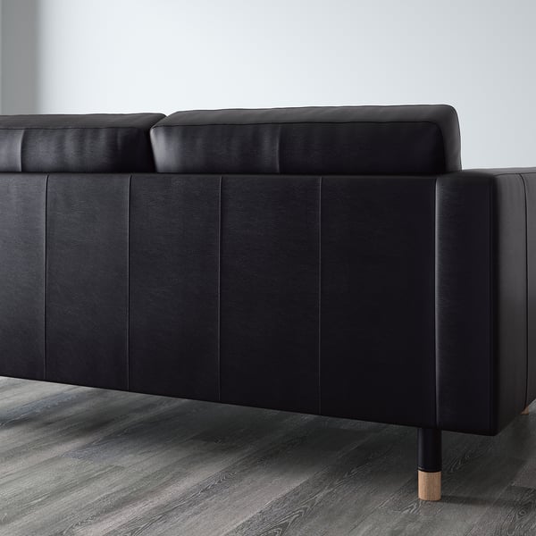 Schwarzes Ledersofa mit gepolsterter Rückenlehne und Sitzfläche. Holzbeine mit goldenen Spitzen. Schlankes, modernes Design.