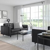 Modernes Wohnzimmer mit großem Fenster und schwarzem LANDSKRONA-Stuhl, elegantem Couchtisch, stilvoller Einrichtung, geräumig und hell.