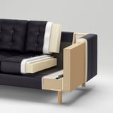 Ein Sofa mit Sichtkonstruktion: Außenseite aus dunklem Stoff, Schaumstoff, Sperrholz, Spanplatten und Massivholzinnen.